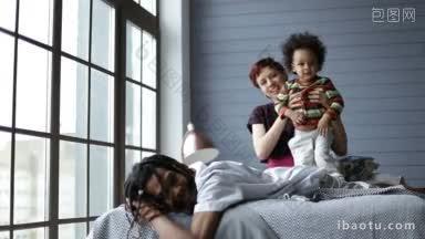 快乐的混合种族家庭一起在家里的卧室里度过美好的<strong>时光</strong>，英俊的非洲爸爸和脏辫放松